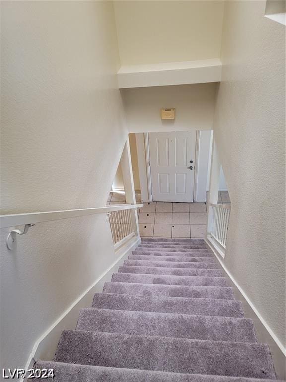 stairway featuring tile patterned flooring