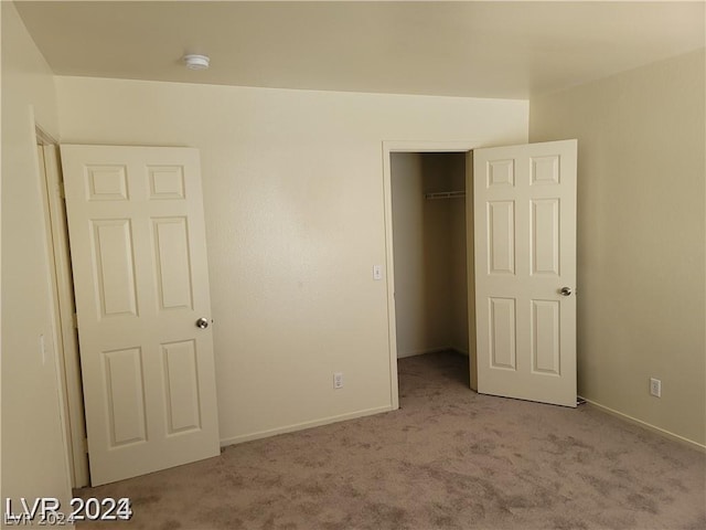 unfurnished bedroom with a closet and light carpet