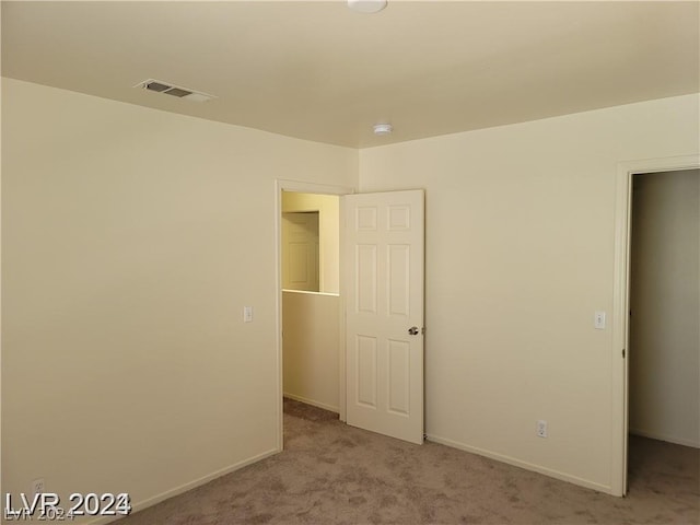 unfurnished room featuring light colored carpet