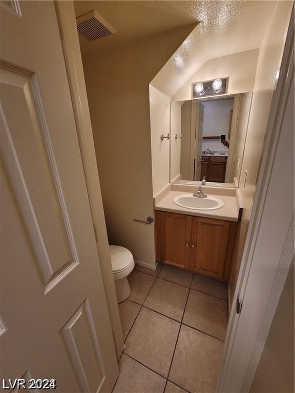 bathroom featuring a textured ceiling, toilet, vanity, and tile patterned flooring