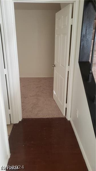 hallway featuring dark carpet