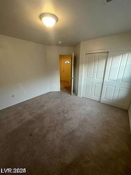 unfurnished bedroom featuring a closet and carpet flooring