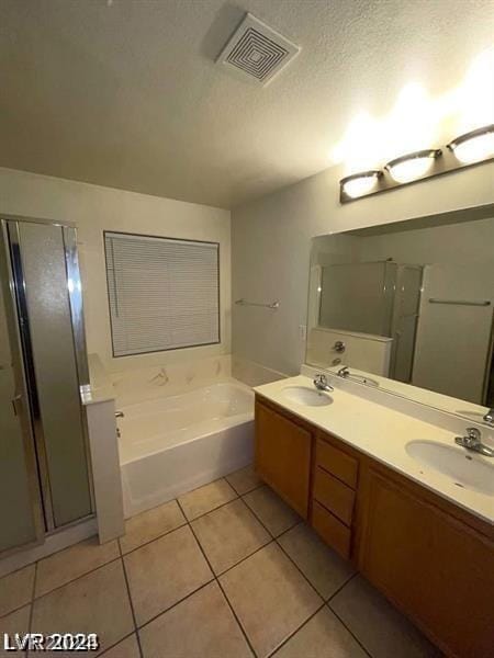 bathroom featuring a textured ceiling, tile patterned floors, vanity, and separate shower and tub