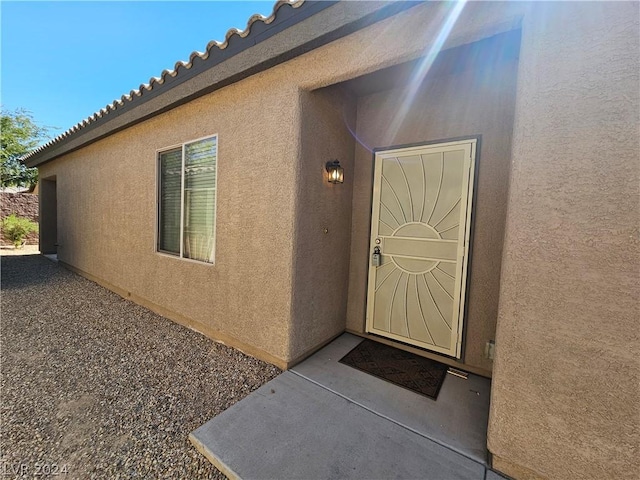 view of exterior entry featuring a patio area