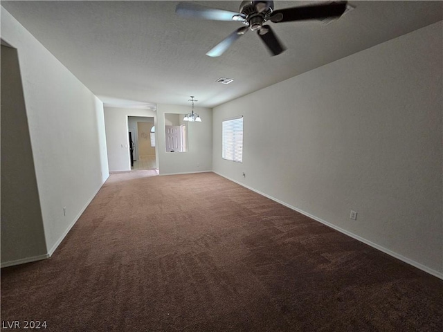 spare room with ceiling fan with notable chandelier and carpet