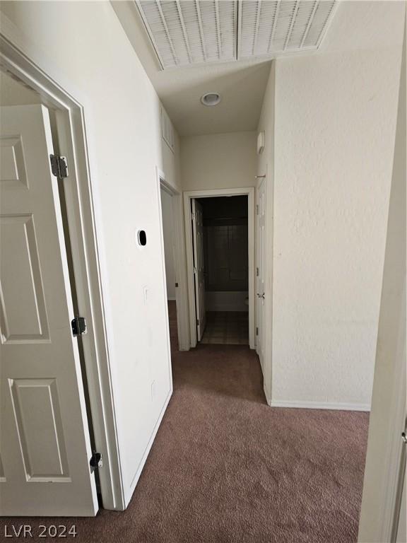 hallway featuring dark colored carpet