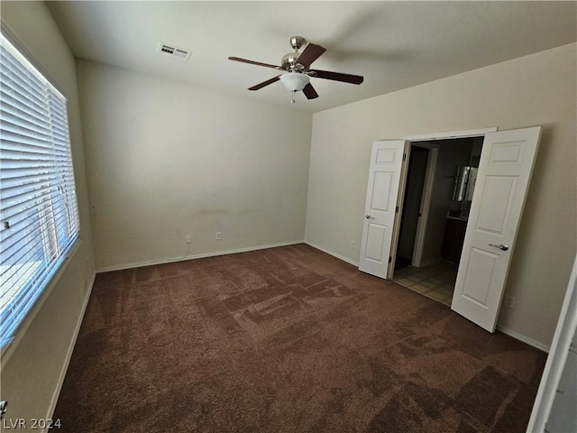 unfurnished bedroom featuring ceiling fan and dark carpet