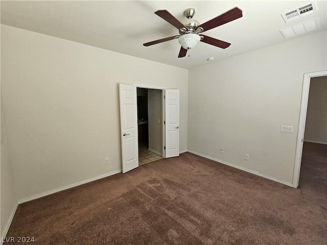 unfurnished bedroom with ceiling fan and dark carpet