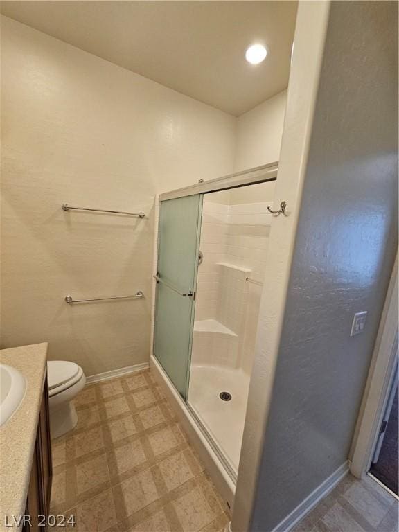 bathroom featuring toilet, walk in shower, and vanity