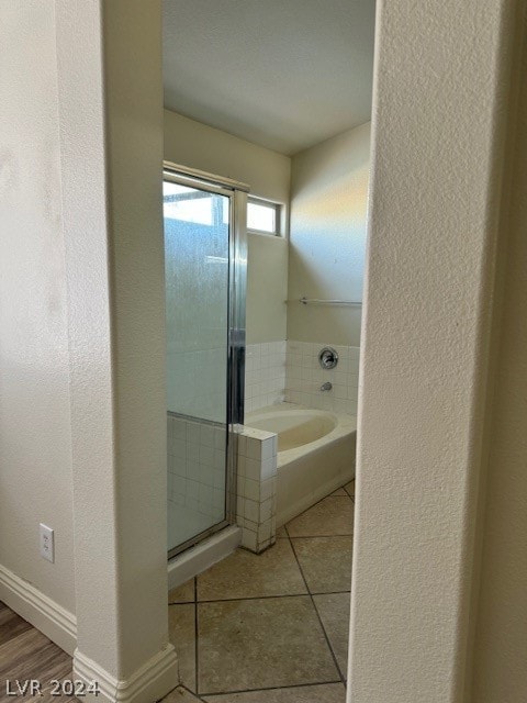 bathroom featuring plus walk in shower and tile patterned flooring