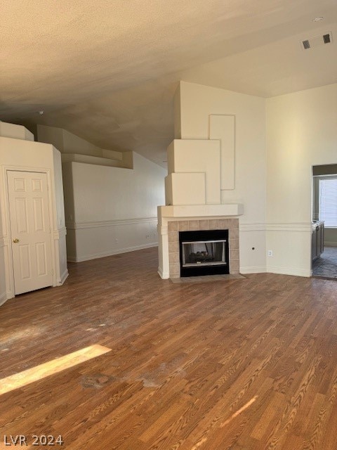 unfurnished living room with a tiled fireplace and hardwood / wood-style flooring