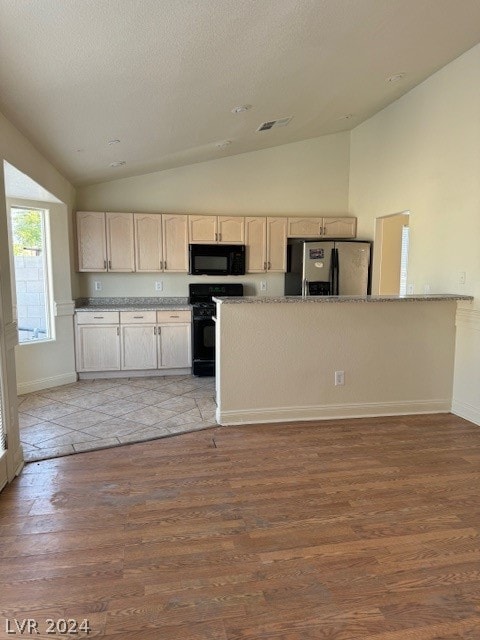 kitchen with range, stainless steel refrigerator with ice dispenser, light brown cabinetry, high vaulted ceiling, and hardwood / wood-style flooring