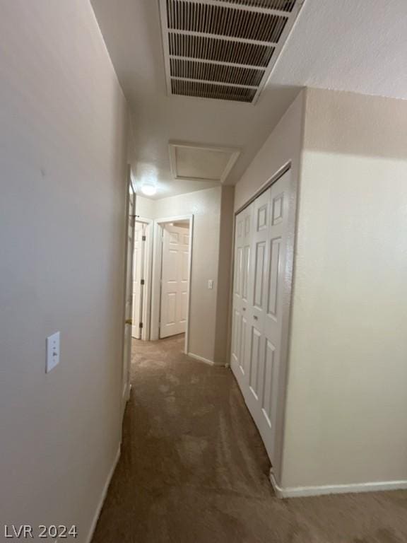 hallway with dark colored carpet