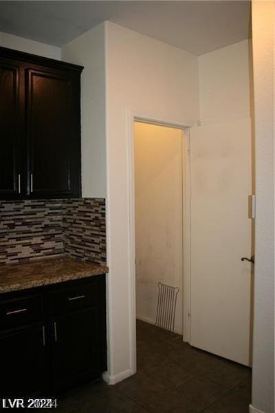 kitchen with decorative backsplash, stone countertops, and dark brown cabinetry