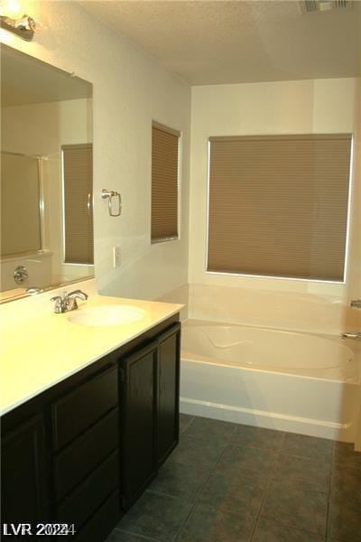 bathroom with vanity, tile patterned floors, and a washtub