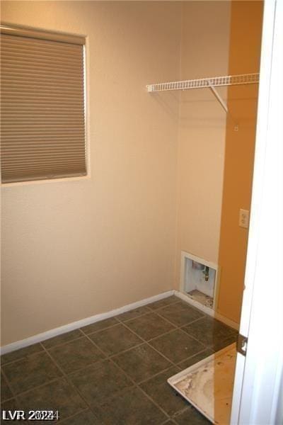 washroom featuring washer hookup and dark tile patterned flooring