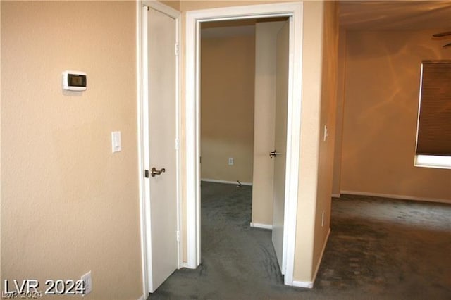 corridor featuring dark colored carpet