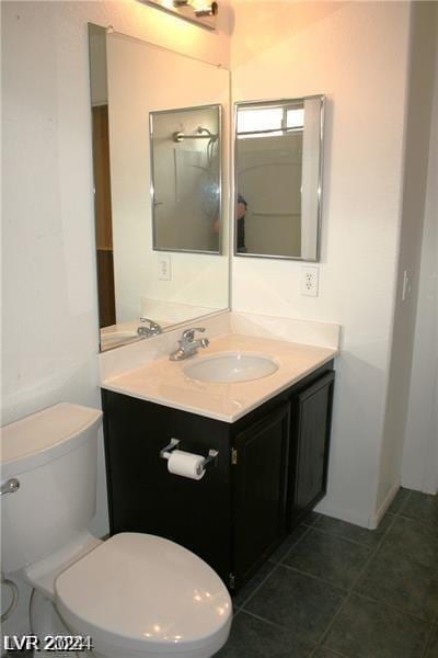 bathroom featuring toilet, tile patterned flooring, and vanity