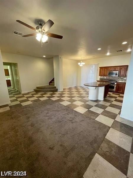 unfurnished living room with ceiling fan with notable chandelier