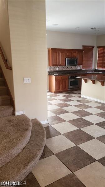 kitchen with decorative backsplash and appliances with stainless steel finishes