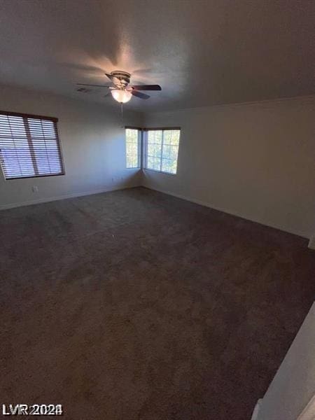 carpeted spare room featuring ceiling fan