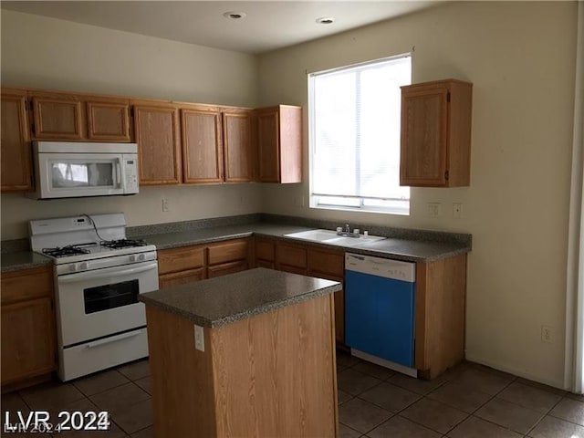 kitchen featuring sink, white appliances, a center island, and tile patterned flooring