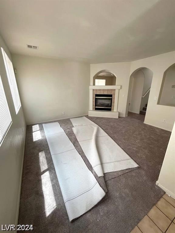 unfurnished living room with a fireplace and carpet flooring