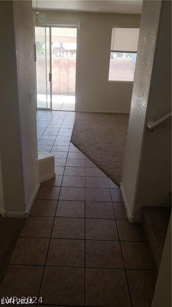 hallway with dark tile patterned flooring