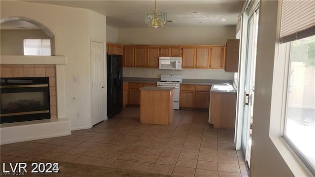 kitchen with white appliances, light tile patterned floors, a healthy amount of sunlight, and a center island