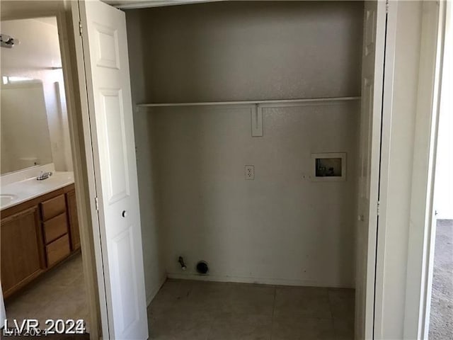 clothes washing area with washer hookup, light tile patterned floors, and sink