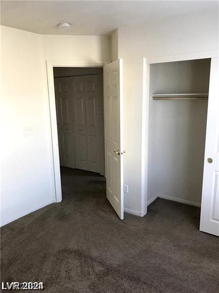 unfurnished bedroom with dark carpet