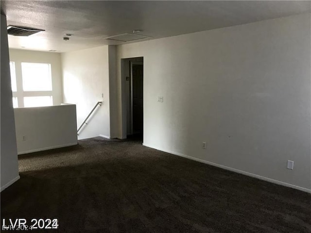 carpeted spare room featuring a textured ceiling