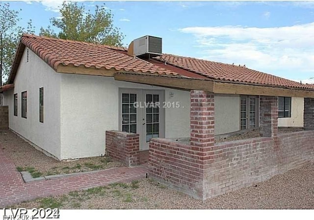 view of front of home with french doors and cooling unit