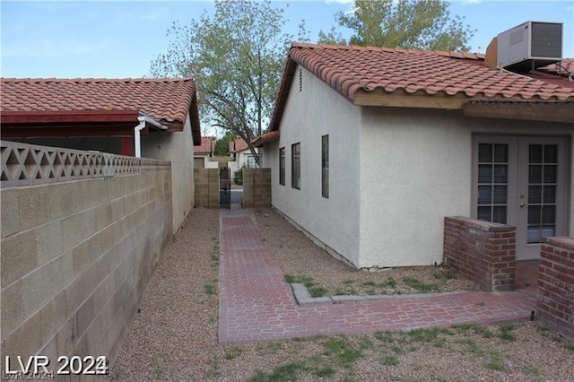 view of property exterior featuring french doors and central AC