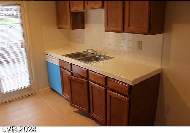 kitchen with tasteful backsplash, sink, and white dishwasher