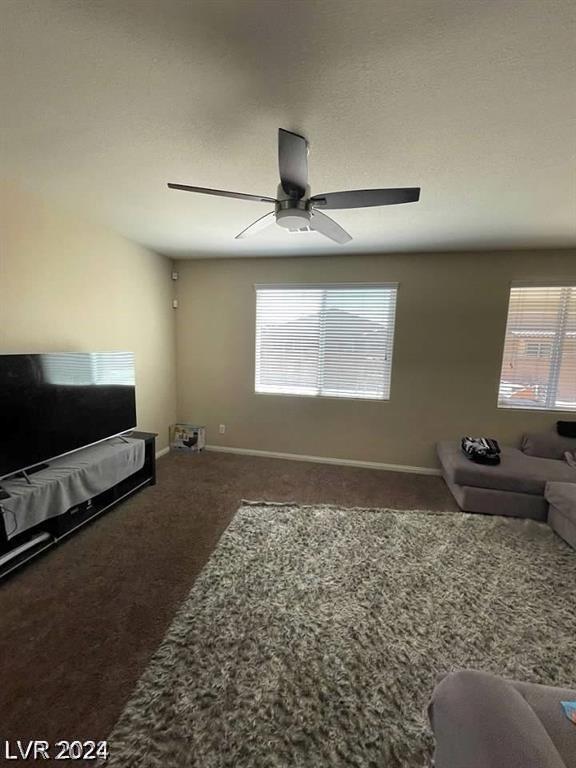 carpeted living room with ceiling fan and a wealth of natural light