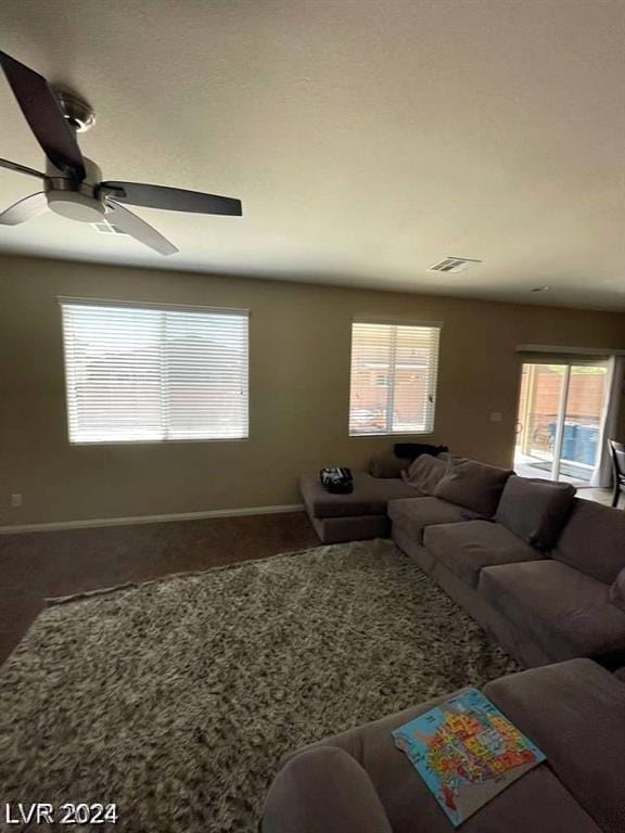 living room with ceiling fan, a wealth of natural light, and carpet flooring