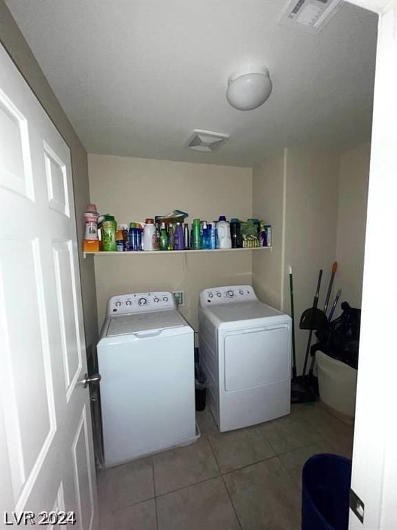 clothes washing area with tile patterned floors and independent washer and dryer