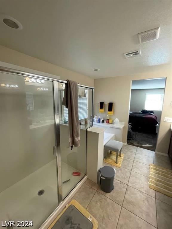 bathroom featuring vanity, tile patterned floors, and a shower with door