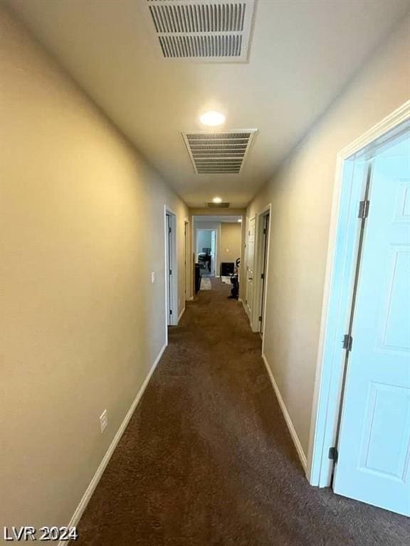 hallway featuring dark colored carpet