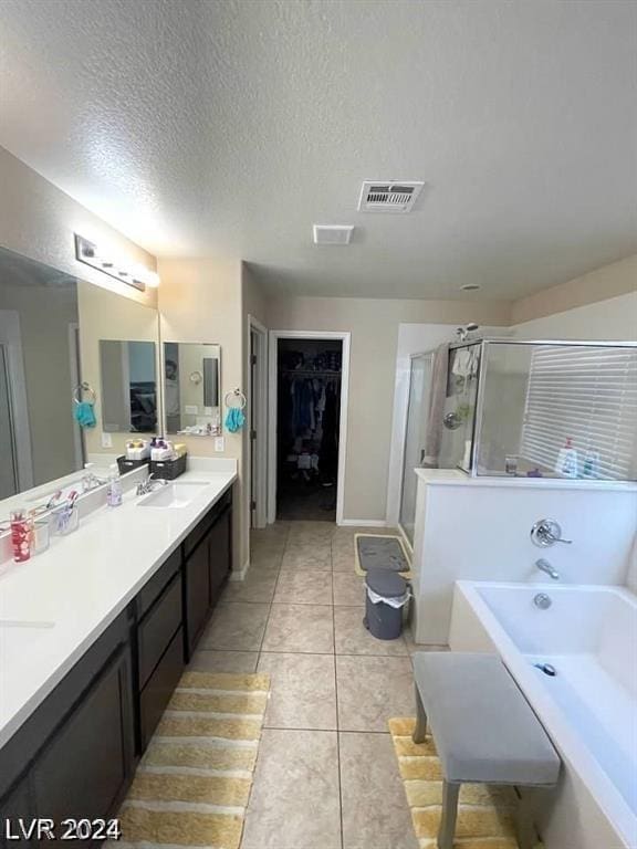 bathroom with plus walk in shower, vanity, tile patterned floors, and a textured ceiling