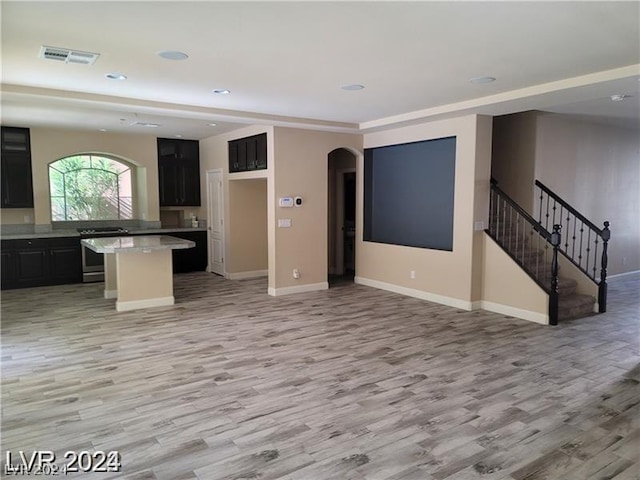 kitchen featuring stainless steel range with electric stovetop, light hardwood / wood-style floors, and a center island