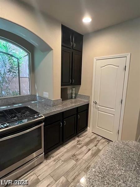 kitchen with gas range and stone countertops