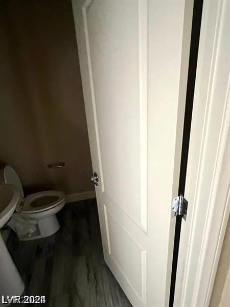 bathroom with wood-type flooring and toilet