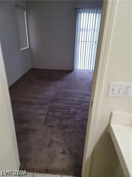 unfurnished room featuring dark colored carpet