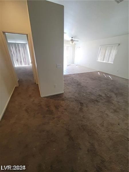 empty room featuring dark colored carpet and ceiling fan