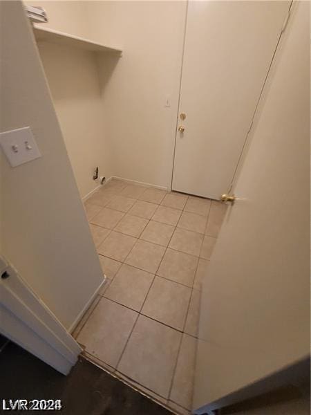 clothes washing area with light tile patterned floors