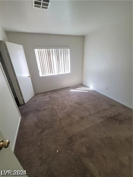 unfurnished room with dark carpet