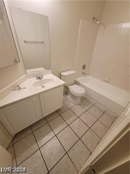 full bathroom featuring toilet, vanity, tile patterned floors, and  shower combination