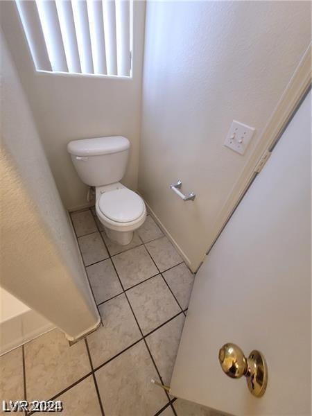 bathroom with toilet and tile patterned floors